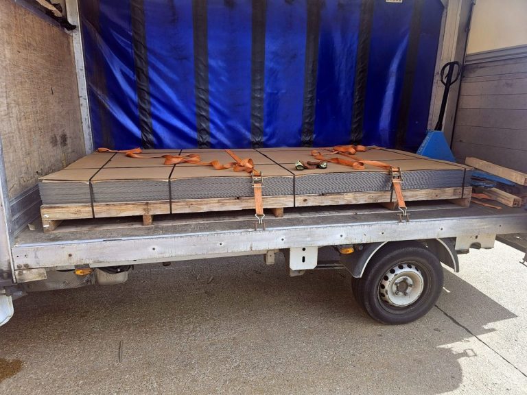 Secured palletised goods inside a blue curtain-side van